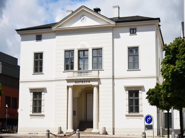 Auf dem Bild ist das historische Rathaus der Stadt Bad Oldesloe bei strahlendem Wetter zu erkennen. Die Vorderseite des Rathauses steht bei dem Bild im Vordergrund.