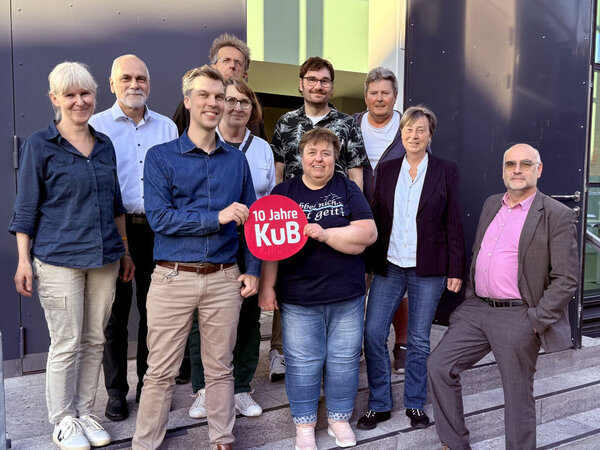 Team des KuB, halten ein schild hoch mit der aufschrift "10 jahre KuB"